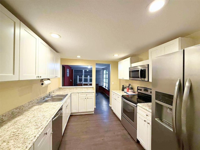 1426 Gary St, Punta Gorda, FL 33982 - kitchen featuring stainless steel appliances, dark wood-style flooring, white cabinets, recessed lighting, and a textured ceiling