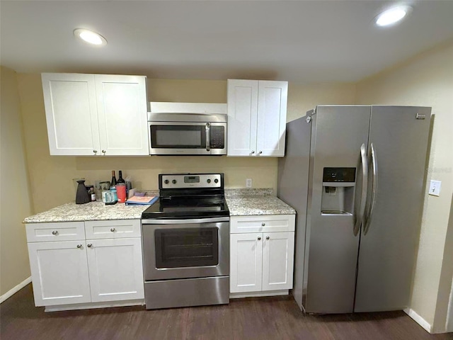1426 Gary St, Punta Gorda, FL 33982 - kitchen with stainless steel appliances, white cabinetry, dark wood-style floors, recessed lighting, and light stone countertops