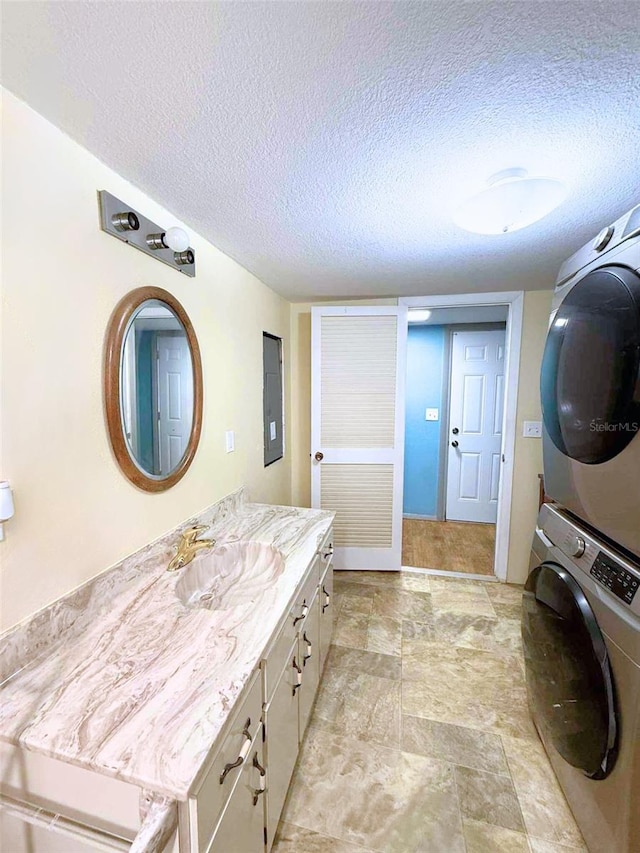 1426 Gary St, Punta Gorda, FL 33982 - bathroom with stacked washer / drying machine, a textured ceiling, vanity, and stone finish floors
