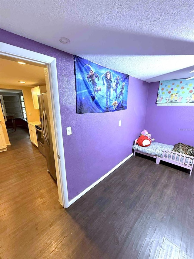 1426 Gary St, Punta Gorda, FL 33982 - bedroom with dark wood-type flooring, a textured ceiling, a textured wall, and freestanding refrigerator