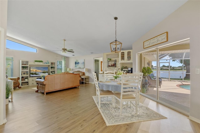2474 Rio De Janeiro Ave, Punta Gorda, FL 33983 - dining room featuring lofted ceiling, light wood-type flooring, a ceiling fan, and a water view