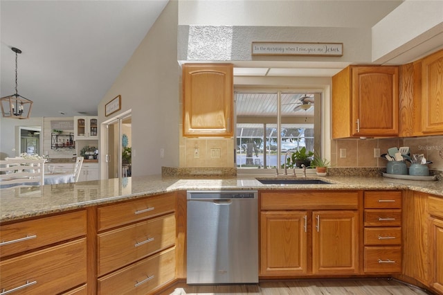 2474 Rio De Janeiro Ave, Punta Gorda, FL 33983 - kitchen with stainless steel dishwasher, backsplash, light stone countertops, brown cabinetry, and a chandelier