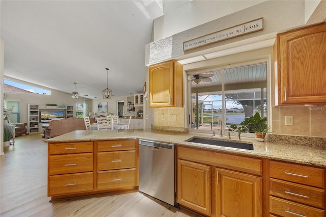 2474 Rio De Janeiro Ave, Punta Gorda, FL 33983 - kitchen with stainless steel dishwasher, a ceiling fan, open floor plan, a peninsula, and light wood-style floors