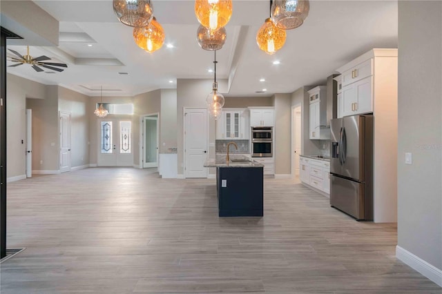4026 Vasco St, Punta Gorda, FL 33950 - kitchen featuring stainless steel appliances, open floor plan, a ceiling fan, backsplash, and a kitchen island with sink