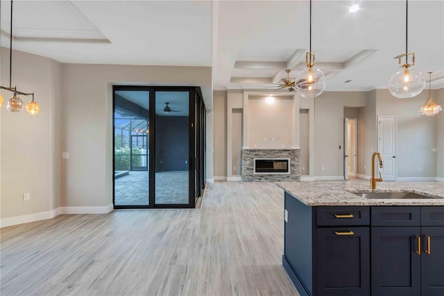 4026 Vasco St, Punta Gorda, FL 33950 - kitchen featuring a ceiling fan, coffered ceiling, light wood finished floors, light stone counters, and open floor plan
