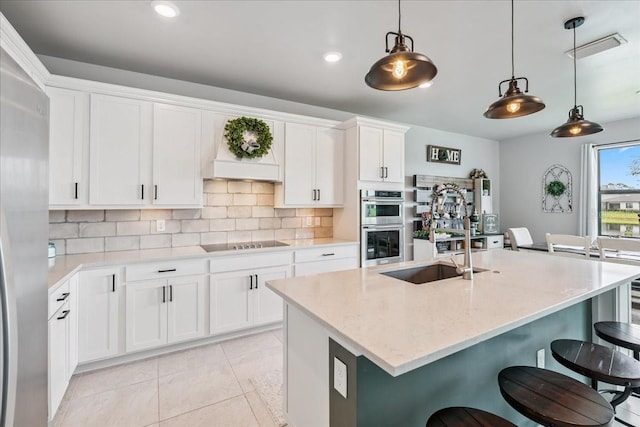 2596 Buckthorn Loop, North Port, FL 34289 - kitchen with stainless steel appliances, backsplash, a kitchen breakfast bar, white cabinets, and pendant lighting