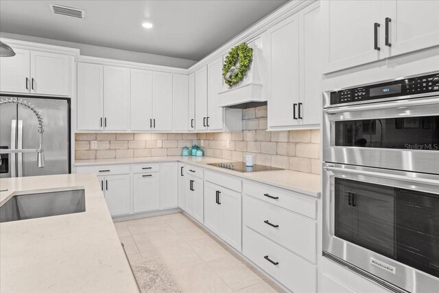 2596 Buckthorn Loop, North Port, FL 34289 - kitchen with appliances with stainless steel finishes, white cabinetry, tasteful backsplash, recessed lighting, and light stone counters