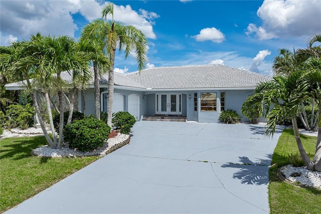 1457 Sea Fan Dr, Punta Gorda, FL 33950 - single story home with french doors, concrete driveway, an attached garage, stucco siding, and a tile roof