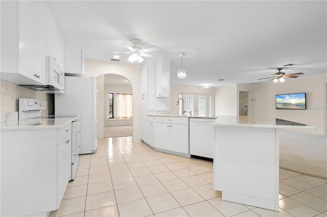 1457 Sea Fan Dr, Punta Gorda, FL 33950 - kitchen featuring white appliances, a ceiling fan, a peninsula, arched walkways, and light tile patterned flooring