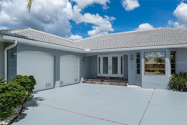 1457 Sea Fan Dr, Punta Gorda, FL 33950 - exterior space featuring french doors, an attached garage, a tile roof, and stucco siding