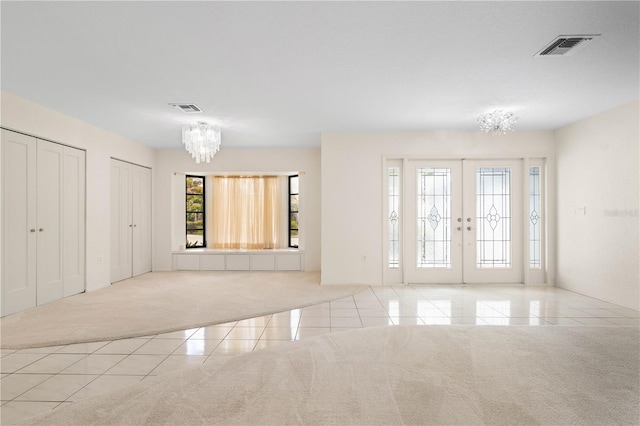 1457 Sea Fan Dr, Punta Gorda, FL 33950 - unfurnished living room featuring a chandelier, carpet, tile patterned flooring, and french doors