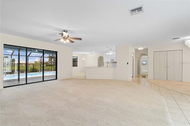 1457 Sea Fan Dr, Punta Gorda, FL 33950 - unfurnished living room with ceiling fan, arched walkways, and light carpet