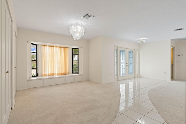 1457 Sea Fan Dr, Punta Gorda, FL 33950 - spare room featuring a chandelier, light tile patterned flooring, and light colored carpet