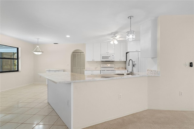 1457 Sea Fan Dr, Punta Gorda, FL 33950 - kitchen with white appliances, ceiling fan, arched walkways, a peninsula, and light countertops