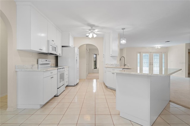 1457 Sea Fan Dr, Punta Gorda, FL 33950 - kitchen featuring white appliances, arched walkways, ceiling fan, and light tile patterned floors
