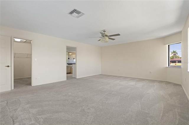1457 Sea Fan Dr, Punta Gorda, FL 33950 - unfurnished bedroom featuring light carpet, a spacious closet, ceiling fan, and ensuite bath