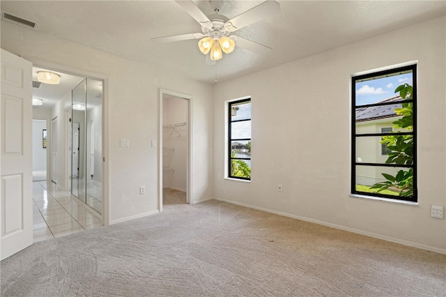 1457 Sea Fan Dr, Punta Gorda, FL 33950 - unfurnished bedroom with light carpet, a spacious closet, and a ceiling fan