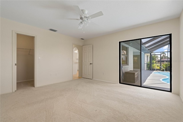 1457 Sea Fan Dr, Punta Gorda, FL 33950 - unfurnished bedroom with access to exterior, carpet, a ceiling fan, and a spacious closet