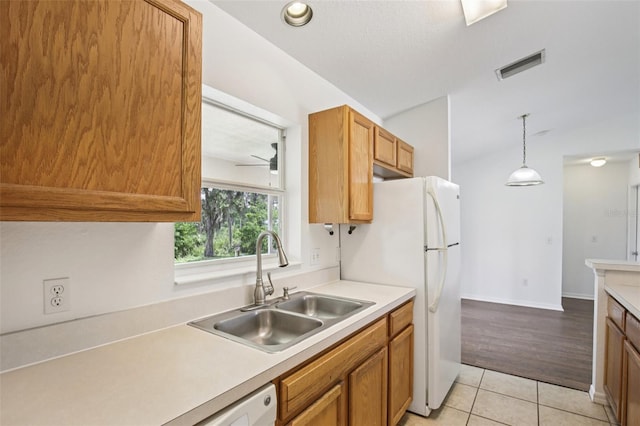 5260 Jessamine Ave, North Port, FL 34291 - kitchen with light tile patterned floors, light countertops, pendant lighting, ceiling fan, and brown cabinetry