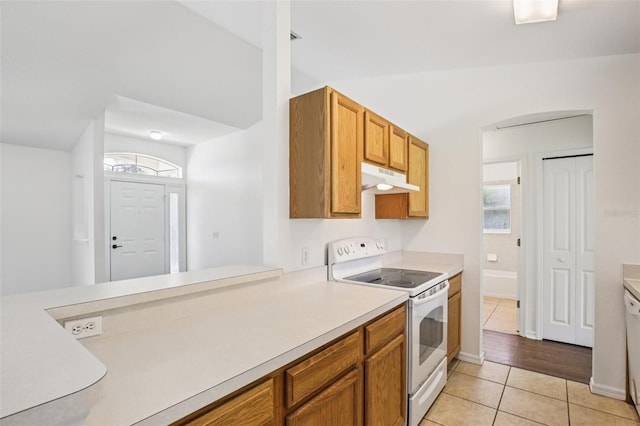 5260 Jessamine Ave, North Port, FL 34291 - kitchen featuring white appliances, under cabinet range hood, light tile patterned floors, light countertops, and plenty of natural light