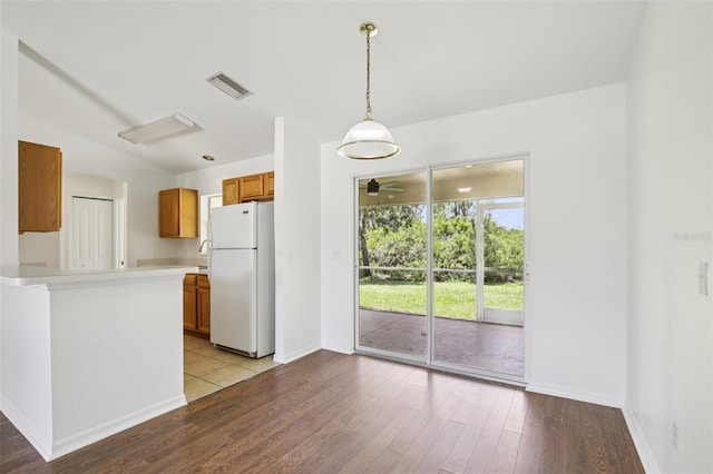 5260 Jessamine Ave, North Port, FL 34291 - kitchen featuring freestanding refrigerator, brown cabinets, wood-type flooring, light countertops, and a ceiling fan