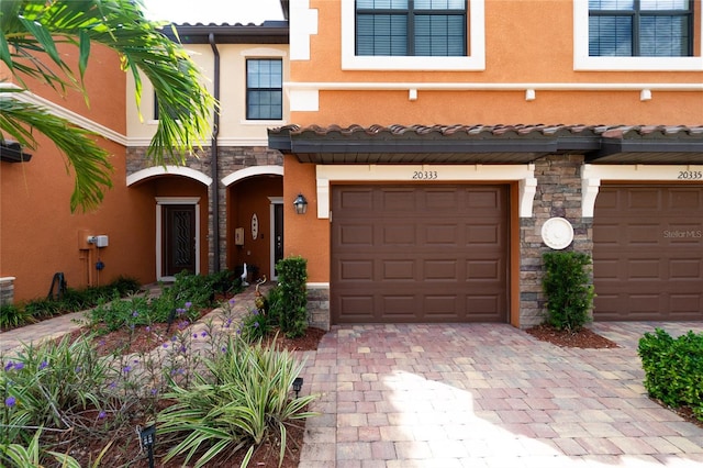 20333 Lagente Cir, Venice, FL 34293 - multi unit property featuring stone siding, an attached garage, stucco siding, and decorative driveway