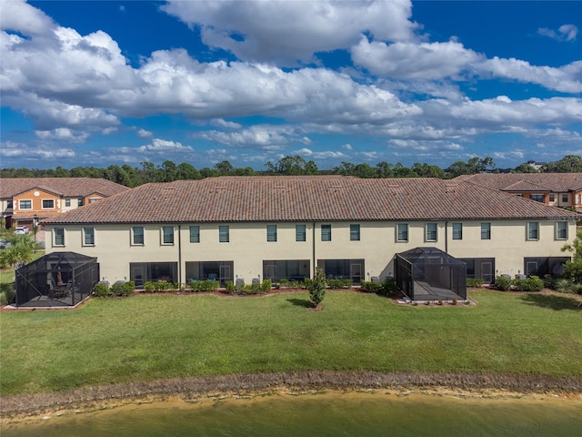 20333 Lagente Cir, Venice, FL 34293 - back of house featuring stucco siding, a tiled roof, glass enclosure, and a yard
