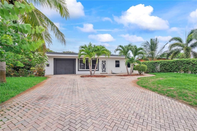1541 NE 32nd Pl, Pompano Beach, FL 33064 - single story home with decorative driveway, stucco siding, an attached garage, and a front lawn