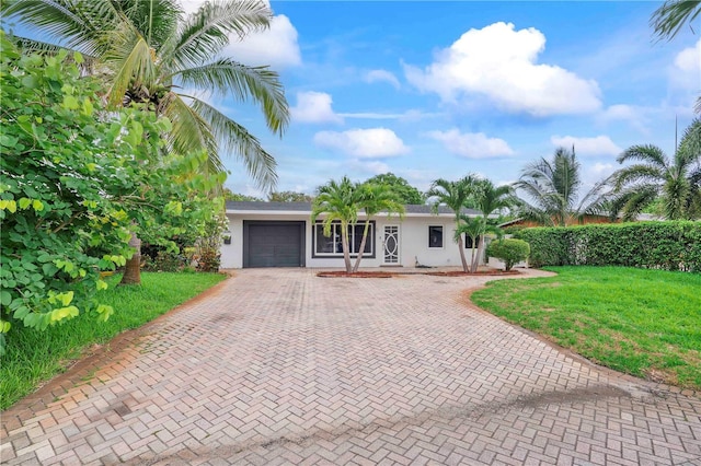 1541 NE 32nd Pl, Pompano Beach, FL 33064 - single story home featuring decorative driveway, stucco siding, an attached garage, and a front lawn