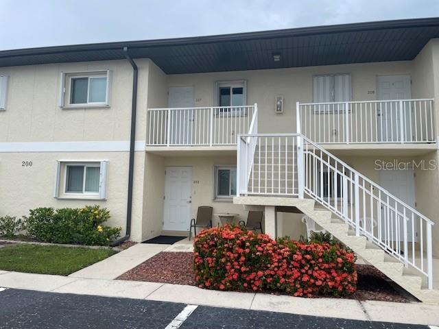 25275 Rampart Blvd Unit 207, Punta Gorda, FL 33983 - view of property featuring stairway and uncovered parking