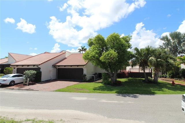 25188 Marion Ave Unit 24, Punta Gorda, FL 33950 - view of front of property featuring an attached garage, a tile roof, a front lawn, and stucco siding