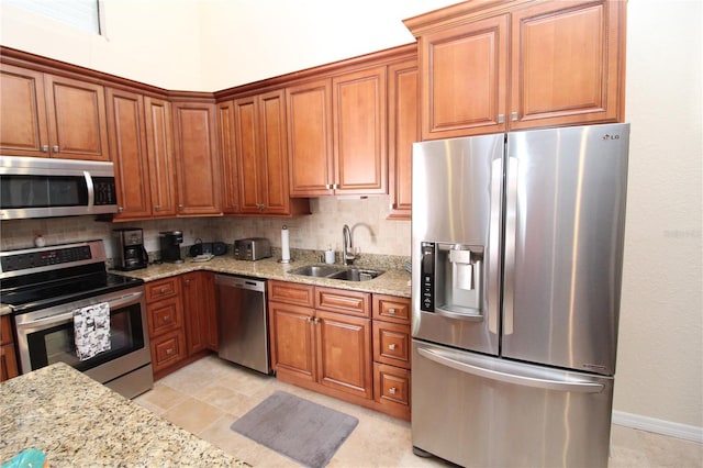 25188 Marion Ave Unit 24, Punta Gorda, FL 33950 - kitchen featuring stainless steel appliances, brown cabinets, light stone counters, and decorative backsplash