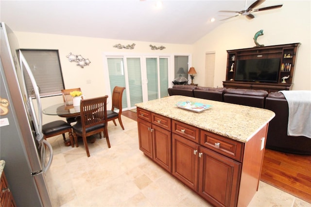 25188 Marion Ave Unit 24, Punta Gorda, FL 33950 - kitchen with freestanding refrigerator, ceiling fan, lofted ceiling, a center island, and light stone countertops