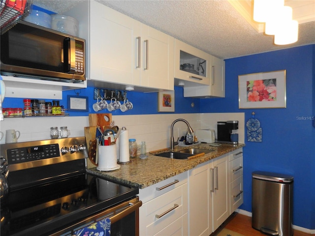 4022 Beaver Ln Unit 700B, Port Charlotte, FL 33952 - kitchen featuring stainless steel appliances, white cabinets, backsplash, a textured ceiling, and stone counters