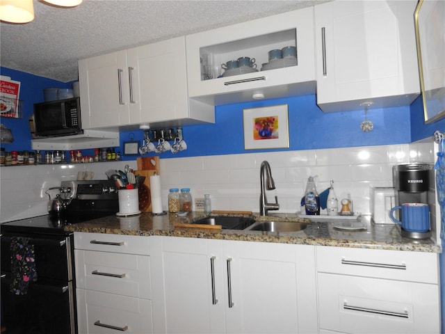 4022 Beaver Ln Unit 700B, Port Charlotte, FL 33952 - kitchen with stainless steel electric range, black microwave, decorative backsplash, white cabinets, and a textured ceiling
