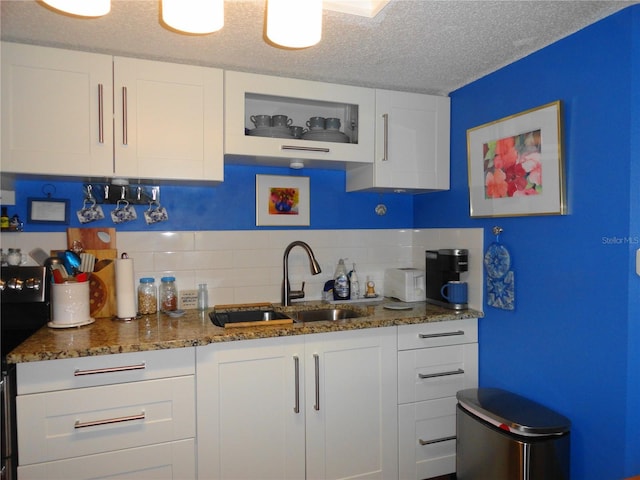 4022 Beaver Ln Unit 700B, Port Charlotte, FL 33952 - kitchen featuring white cabinetry, backsplash, a textured ceiling, and dark stone counters