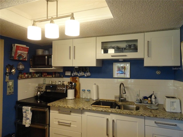 4022 Beaver Ln Unit 700B, Port Charlotte, FL 33952 - kitchen with double oven range, black microwave, backsplash, white cabinetry, and light stone counters