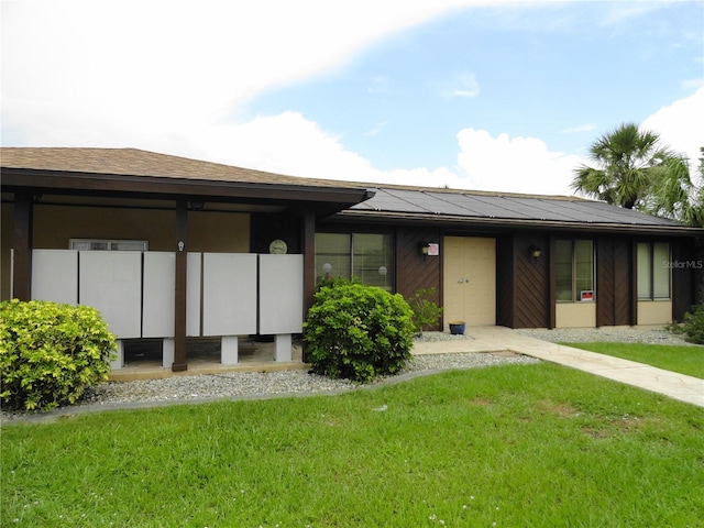 4022 Beaver Ln Unit 700B, Port Charlotte, FL 33952 - view of front facade featuring roof mounted solar panels and a front yard