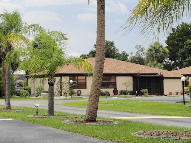 4022 Beaver Ln Unit 700B, Port Charlotte, FL 33952 - view of front of house featuring a front lawn, stucco siding, and a shingled roof