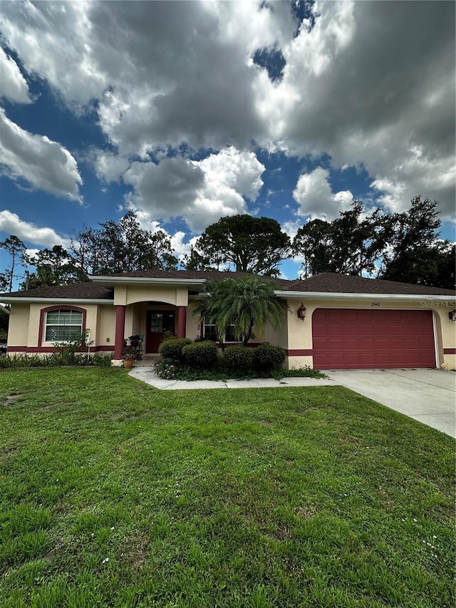 2942 Traverse Ave, North Port, FL 34286 - view of front facade featuring stucco siding, concrete driveway, a garage, and a front yard