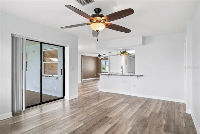 572 Darwin Rd, Venice, FL 34293 - unfurnished living room with a ceiling fan and light wood finished floors