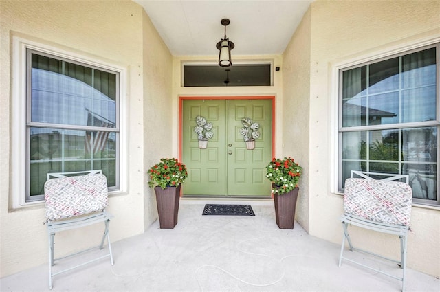 860 Silver Springs Ter NW, Port Charlotte, FL 33948 - doorway to property featuring covered porch and stucco siding