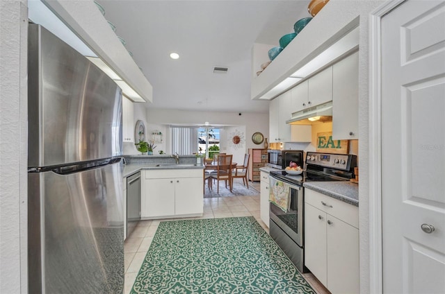 860 Silver Springs Ter NW, Port Charlotte, FL 33948 - kitchen with appliances with stainless steel finishes, under cabinet range hood, a peninsula, white cabinetry, and recessed lighting