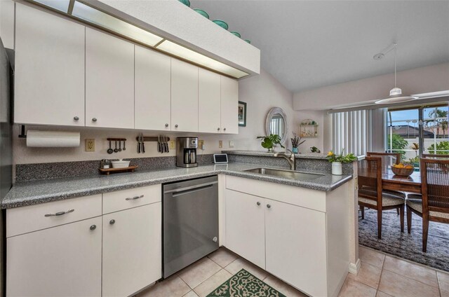 860 Silver Springs Ter NW, Port Charlotte, FL 33948 - kitchen featuring stainless steel dishwasher, a peninsula, light tile patterned flooring, white cabinets, and lofted ceiling
