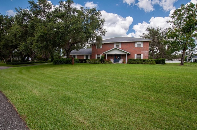 3990 NE Ashley Ter, Arcadia, FL 34266 - view of front facade featuring a front yard and brick siding