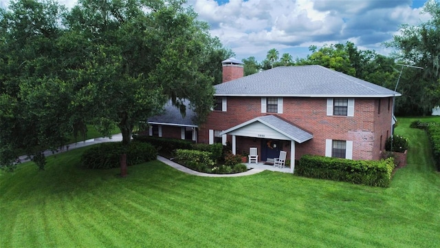 3990 NE Ashley Ter, Arcadia, FL 34266 - view of front of home with a front lawn, a chimney, a porch, and brick siding
