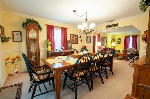 3990 NE Ashley Ter, Arcadia, FL 34266 - dining area with light colored carpet, a chandelier, ornamental molding, and arched walkways