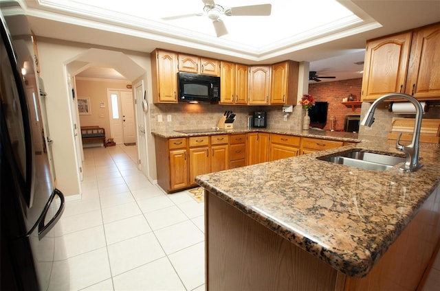 3990 NE Ashley Ter, Arcadia, FL 34266 - kitchen featuring black appliances, ceiling fan, arched walkways, light stone counters, and decorative backsplash