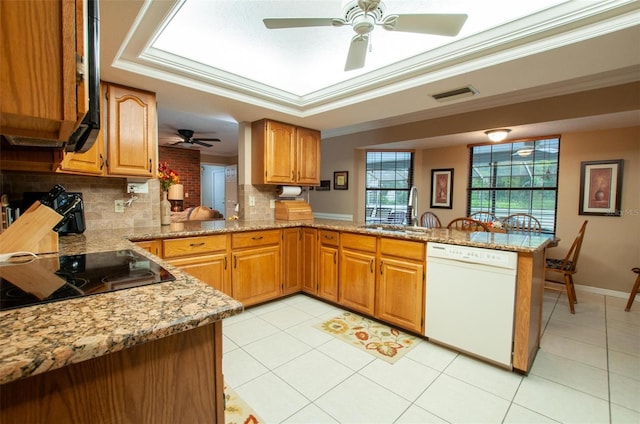 3990 NE Ashley Ter, Arcadia, FL 34266 - kitchen featuring white dishwasher, a peninsula, black electric stovetop, ceiling fan, and backsplash