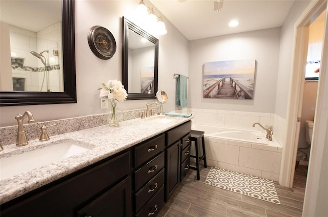 3990 NE Ashley Ter, Arcadia, FL 34266 - bathroom featuring a bath, double vanity, wood finished floors, and tiled shower